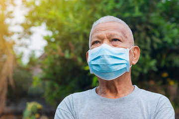 Portrait of elderly man with short white hair, wearing face mask for health because have air...