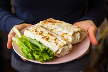 Woman holds dieting vegan wraps with vegetables in hands. Vegetarian food. 