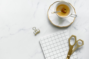 Minimal teacup by a grid notebook