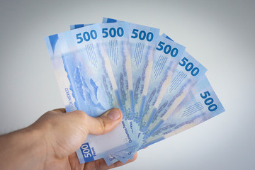 Hand holding many mexican pesos of 500