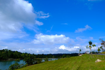 green field with lake and sky background