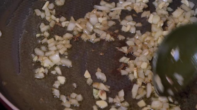 Cooking fries onions in a pan in olive oil