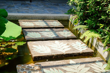 little pond with walkway in front of the house
