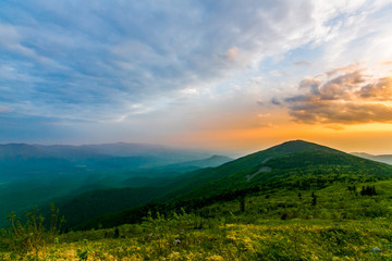 Obraz premium Piękny krajobraz. Jasny kolorowy zachód słońca otwierający się ze szczytu góry latem. Burzowe chmury podczas zachodu słońca. zrelaksować się
