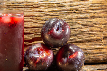 Plum juice (Prunus sp.) Served in a glass with ice and fresh fruits