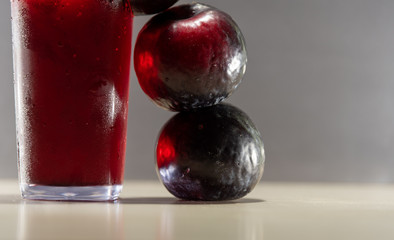 Plum juice (Prunus sp.) Served in a glass with ice and fresh fruits