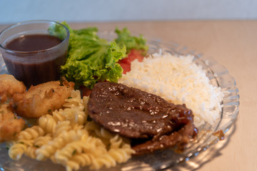 Popular dish of Brazilian food with rice beans pasta with meat and salads