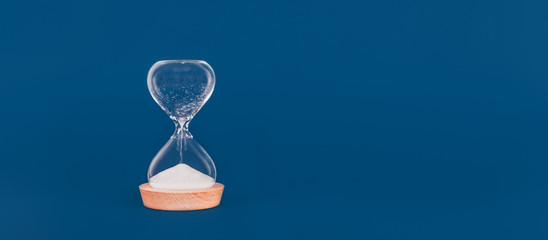 Hourglass with the last drops of sand. Concept of time and timely actions, closing opportunities....