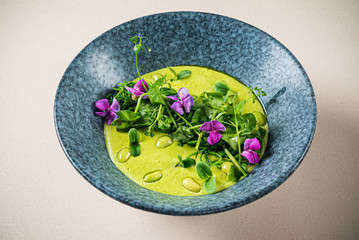 green cream soup with edible flowers
