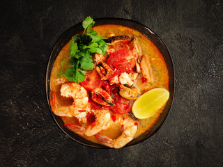 traditional tom yam soup. Fashionable and modern Asian cuisine. top view of spicy shrimp and broth. copy space for your layout.