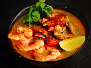 traditional tom yam soup. Fashionable and modern Asian cuisine. Close-up photo of spicy shrimp and broth.