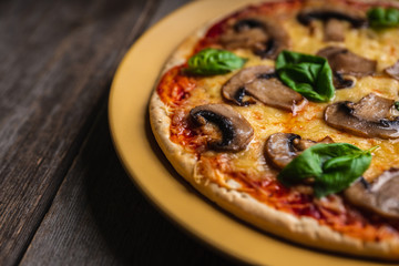Freshly making pizza with mushrooms served on the rustic background. Selective focus. Shallow depth of field.