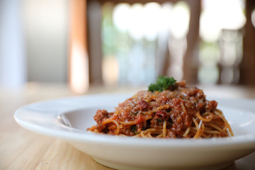 spaghetti Bolognese with minced beef and tomato sauce garnished with parmesan cheese and basil ,...