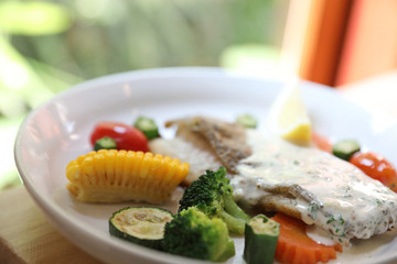 Sea bass fillet , baked sea bass with lemon sauce on wood background