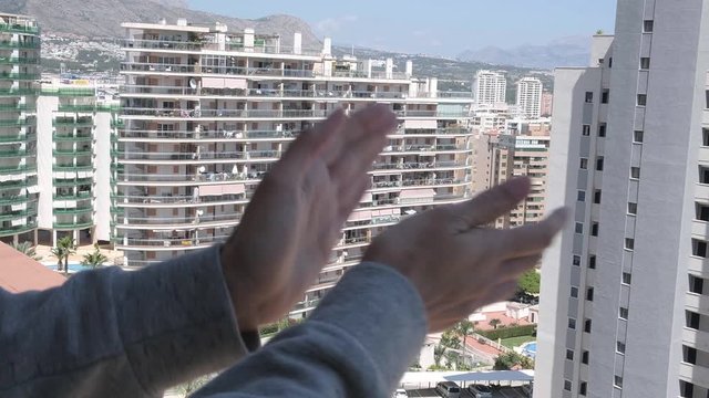 Woman hands applauding medical staff from their balcony. People in Spain clapping on balconies and windows in support of health workers during the Coronavirus pandemic
