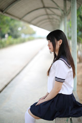 Fototapeta premium Asian school girl sitting with outdoor background