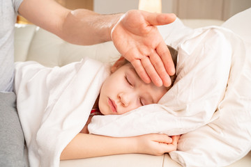 Fototapeta na wymiar daddy hand touches forehead of patient daughter.