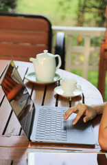 Closeup of woman's hand doing her work with notebook computer at home. Work-from-home, social distancing during COVID-19 outbreak around the world. New normal lifestyle. Vertical view. 