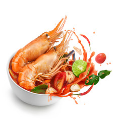 Thai food Tom Yum Gong.Thai hot and spicy soup shrimp in bowl.with Straw Mushroom,lime,Kaffir lime leaves,tomato and chilli. Splash on the air. isolated on white background.
