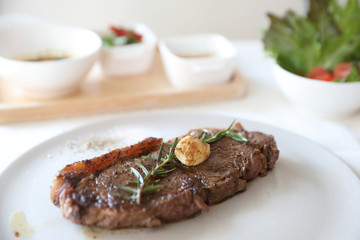 beef steak with salad on white table