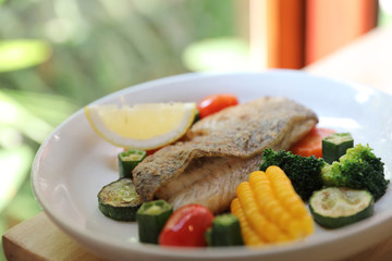 Sea bass fillet , baked sea bass with lemon sauce on wood background