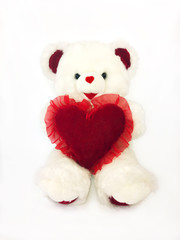 White stuffed teddy bear holding red heart