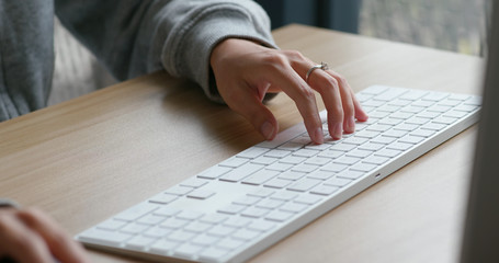 Woman type on desktop computer