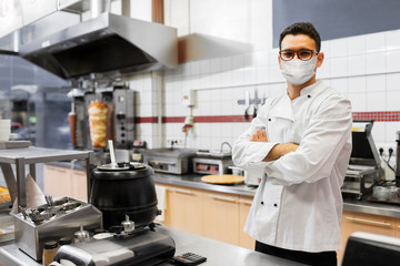 health protection, safety and pandemic concept - male chef cook wearing face protective medical...