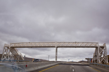 Naklejka premium Bridges crossing people without a roof. Open road with blue clouds . The pedestrian crossing bridge .