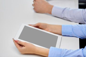 business, people and technology concept - close up of businesswoman with tablet pc at office