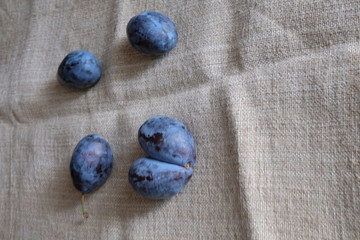 plums of different sizes on a light background of burlap healthy food vitamins
