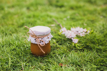 Caramel salt in a jar. Caramel sauce in a jar on the grass.