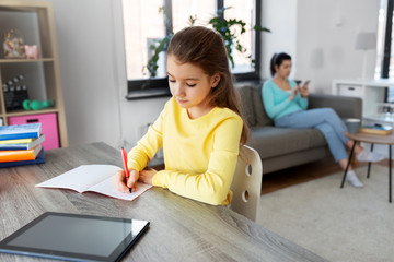 children, education and distant learning concept - student girl with tablet pc computer writing to...