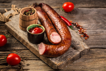 Traditional sausages smoked in apple, beech and juniper wood. closeup on a wooden board