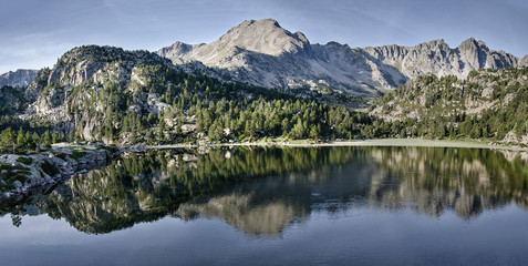 Fototapeta na wymiar Paisaje las montañas de los pirineos de Andorra reflejado en el agua de un estanque.