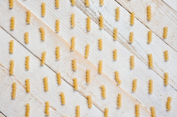 Spiral pasta on a white wooden background. Background for cooking and food.
