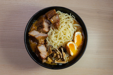 A bowl of curry ramen with pork, egg, and mushroom.