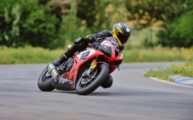 Motorcycle practice leaning into a fast corner on track