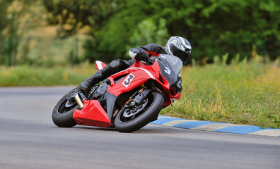 Motorcycle practice leaning into a fast corner on track