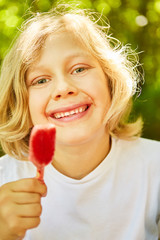 Glücklicher blonder Junge beim Eis essen