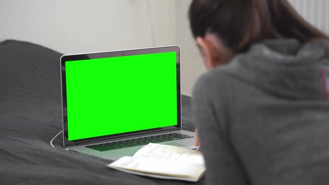 Young woman doing online education remotely at her home. Green screen. Work from home. Quarantine