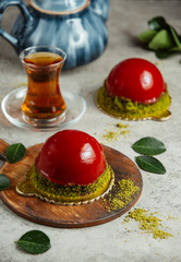 cake with red topping and glass of tea