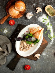 chicken breast with mushrooms in a creamy sauce and puff bread