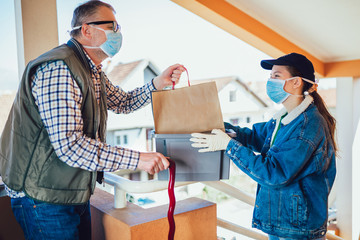 Teenage girl is delivering some groceries to an elderly person.Contactless delivery during the...