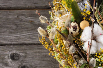 Wreath of dried twigs and flowers on a wooden background. Natural decoration. Celebration concept. Easter wreath. Willow round frame. Copy space.