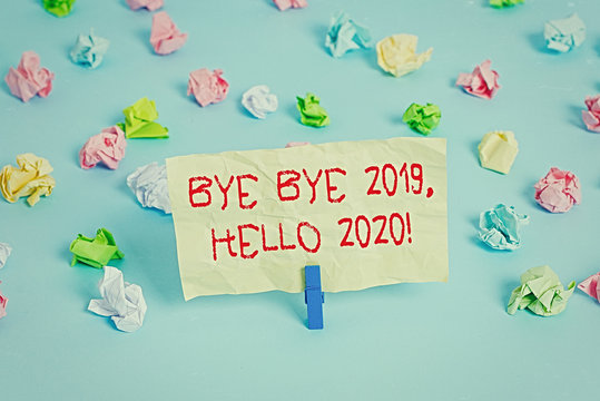 Word writing text Bye Bye 2020 Hello 2020. Business photo showcasing saying goodbye to last year and welcoming another good one Colored crumpled papers empty reminder blue floor background clothespin