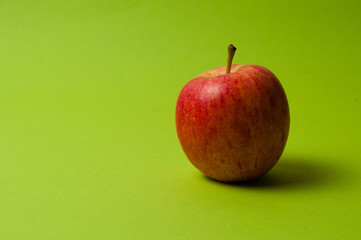 Apple on green background. Healthy eating, calorie count and weight loss concept