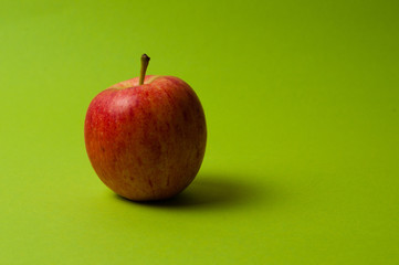 Apple on green background. Healthy eating, calorie count and weight loss concept