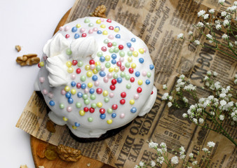 Glazed Easter cake decorated with marshmallows and food decorative elements on the table for the traditional Christian holiday Easter