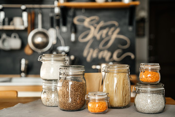 Various cereals Buckwheat, lentils, oatmeal, pasta, are stored in glass jars on the background of...